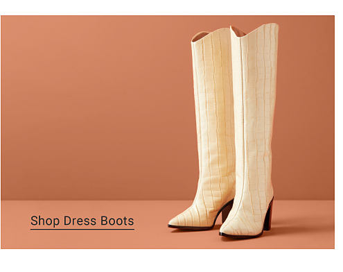 A pair of tall beige boots with a block heel. Shop Dress Boots.