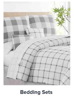 Image of a bed with white and gray bedding. Shop bedding sets. 