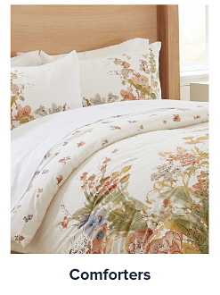 Image of a bed with a floral comforter. Shop comforters. 