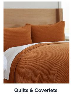 mage of a bed with an orange bedspread. Shop quilts and coverlets. 