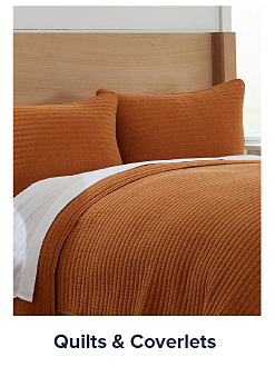 mage of a bed with an orange bedspread. Shop quilts and coverlets. 