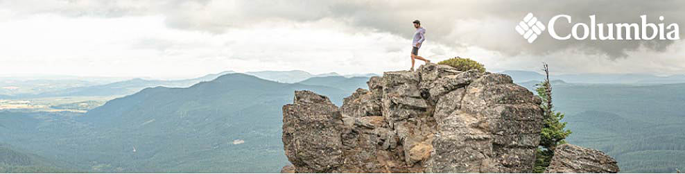 Image of a man hiking on a large rock. Columbia logo.