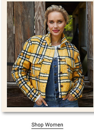 A woman wearing a yellow, black and white plaid jacket over a denim jumpsuit. Shop women.