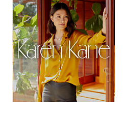 A woman wearing a yellow blouse. Shop Karen Kane.