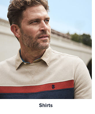 A man in a striped sweatshirt worn over a dress shirt. Shop shirts.