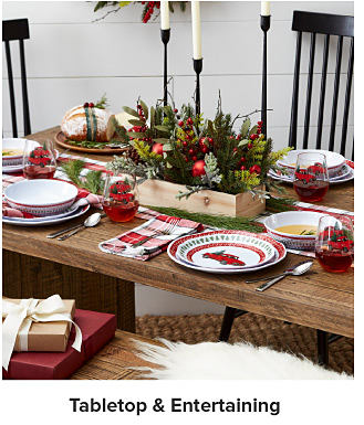 A wooden table with Christmas dinnerware. Shop tabletop and entertaining.