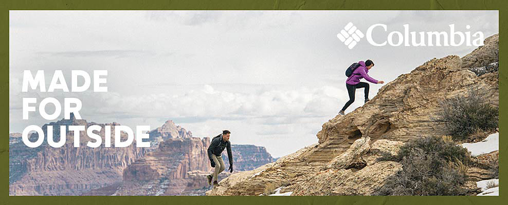 A man and a woman hiking up a mountain and wearing Columbia clothing. Made for outside. The Columbia logo.