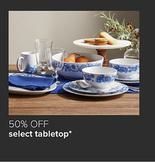White plates and bowls with blue floral detailing. 50% off select tabletop. 