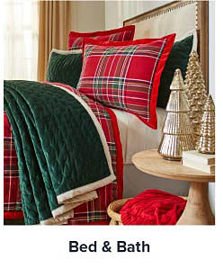 Image of a red plaid bed with green throw blanket. Shop bed and bath.