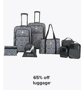 A black and white luggage set with rolling suitcases, shoe bag, tote bag, and other small bags. 65% off luggage. 