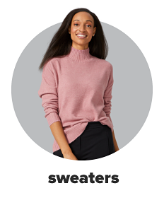 A woman wears a turtle neck, blush pink sweater. Shop sweaters.