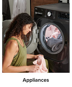 A woman taking laundry out of a dryer. Shop appliances.