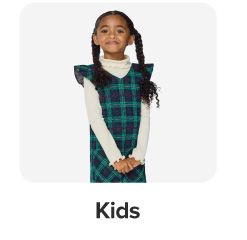 A girl in a blue and green plaid dress. Shop kids.