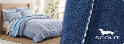 Image of a bed with blue bedding. Scout logo