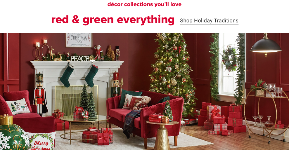 A red living room decorated for the holidays. A lit up decorated christmas tree sits in a corner with an assortment of gifts wrapped underneath it, beside a white fireplace and red sofa. The fireplace has green stockings hanging from it with christmas signs and nutcrackers around it. Decor collections you'll love, red and green everything. Shop Holiday traditions.