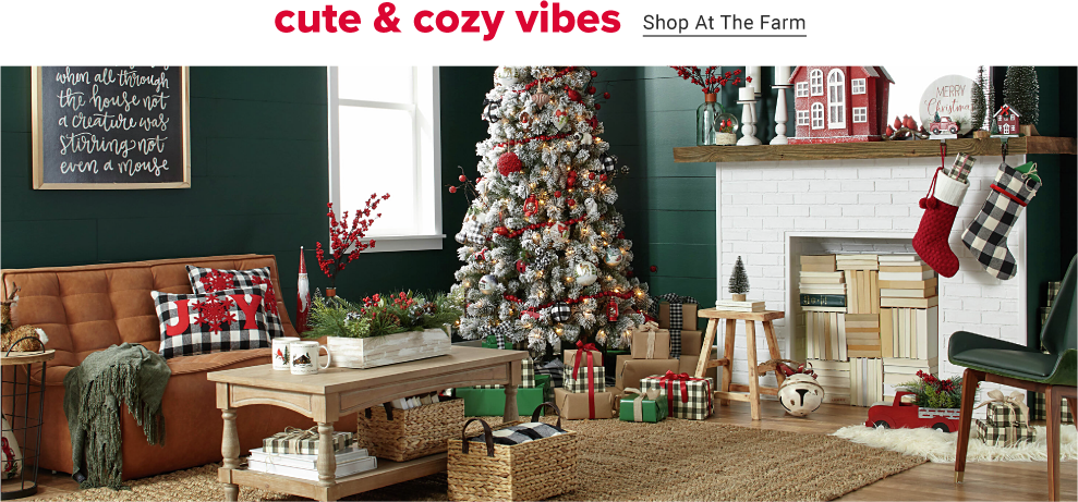 A green living room decorated room for christmas has a collection of classic christmas decorations, from a white frosted pine christmas tree to plaid and red stockings under the white fireplace. Plaid wrapped gifts lie under the tree. Cute and cozy vibes. Shop at the farm.