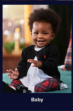 An image of a baby in a cardigan and plaid pants. Shop baby.