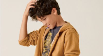 A boy in a gold sweater. Shop kids.