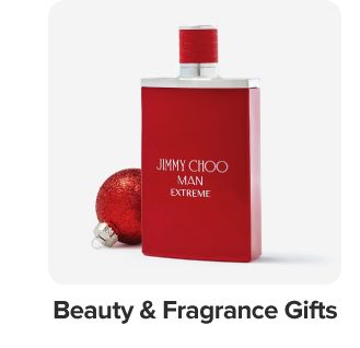 Image of a bottle of cologne and a red ornament. Beauty and fragrance gifts.