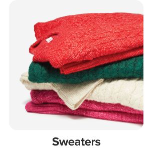 Image of a stack of sweaters in different holiday colors. Sweaters.