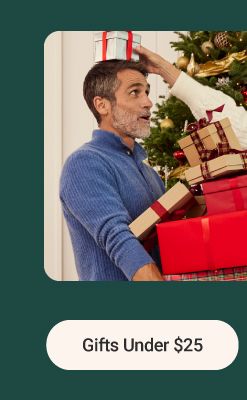 Image of a man and woman holding presents in front of a Christmas tree. The gift shop. Gifts under $25.