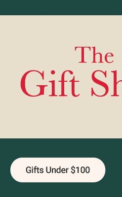 Image of a man and woman holding presents in front of a Christmas tree. The gift shop. Gifts under $100.