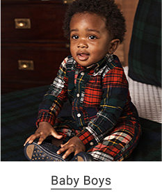 A baby boy wearing red, green and white plaid pajamas. Baby boys.