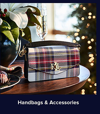 An image of a plaid-printed handbag on a table. Shop handbags and accessories.