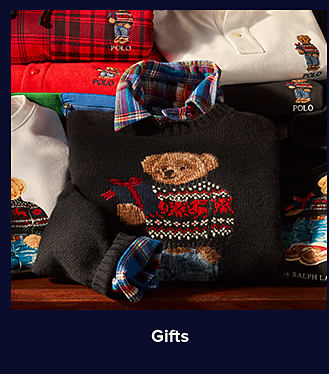 An image of a stack of Polo Bear-printed sweaters. Shop gifts.