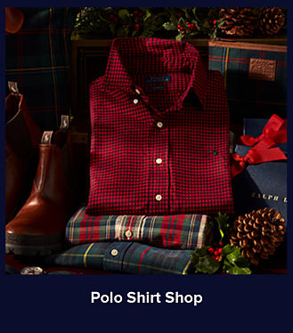 An image of a stack of button-down shirts next to a pair of brown leather boots. Shop Polo Shirt Shop.