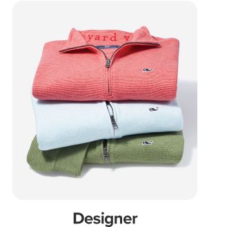 Image of a stack of pullover sweaters. Shop designer.