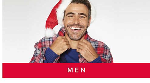 An image of a man in a red plaid shirt with a red Santa hat. Shop men.