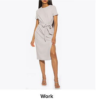 A woman in a grey knee length dress. Shop work dresses.