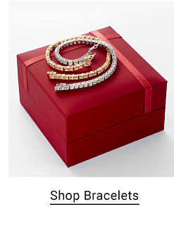 An image of a silver bracelet and a gold bracelet on a red box. Shop bracelets.