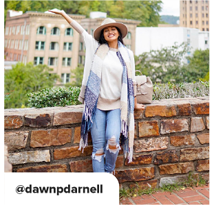 A woman in light denim with holes near her knees, with a white and beige sweater. She wears a beige hat and a blue and white striped sweater. At Dawn p Darnell. 
