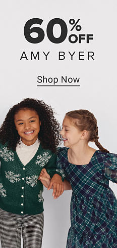 Image of one young girl in a green cardigan with snowflakes on it and another girl in a plaid dress. 60% off Amy Byer. Shop now.