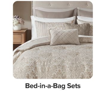 A bed with beige bedding. Shop bed in a bag sets.