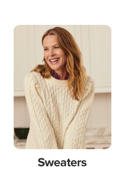 An image of a woman wearing a sweater. Shop sweaters.