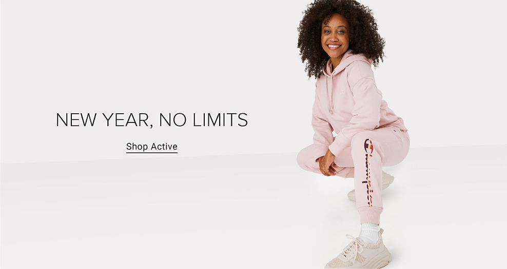 Woman wearing a light pink Champion sweatsuit. New year, no limits. Shop active. 