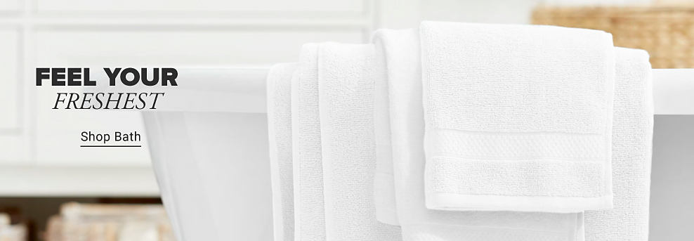 A bath tub with towels draped over the side. Feel your freshest. Shop bath.