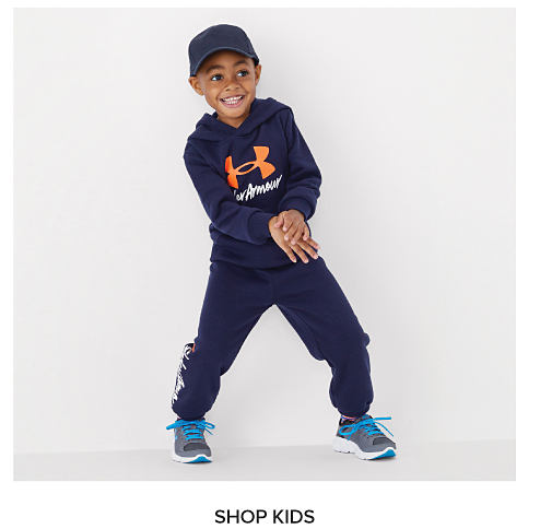 A boy in a blue Under Armour set. Shop kids.
