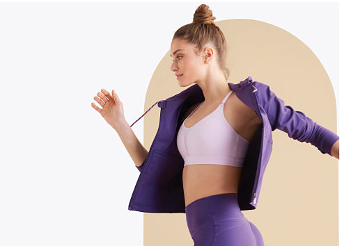 A woman running in a purple activewear set. The Active Shop.