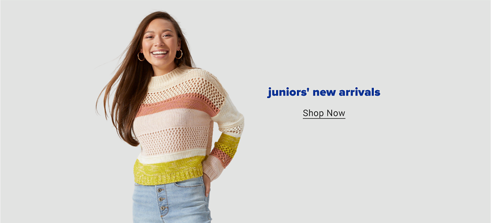 A woman in a tan, pink, yellow and white striped sweater and blue jeans. Juniors new arrivals. Shop now. 