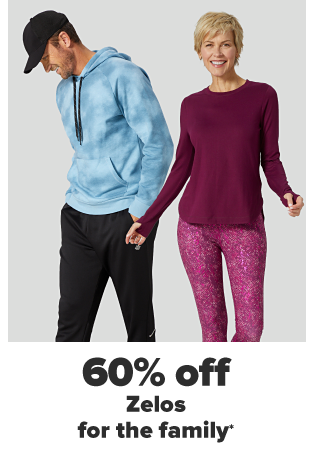A man in a black hat, a blue tie dye hoodie and black athletic pants. A woman in a maroon longsleeve shirt and maroon patterned leggings. 60% off Zelos for the family. 