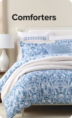 Shop comforters. A bed with blue bedding.