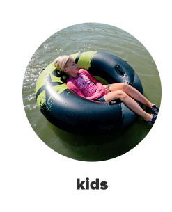 A little girl in a pink outfit laying in a black and green inflatable tube. Kids. 