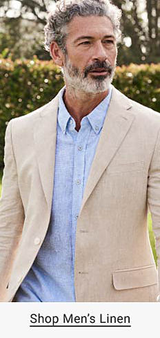 A man in a tan sport coat and a light blue linen dress shirt. Shop men's linen.
