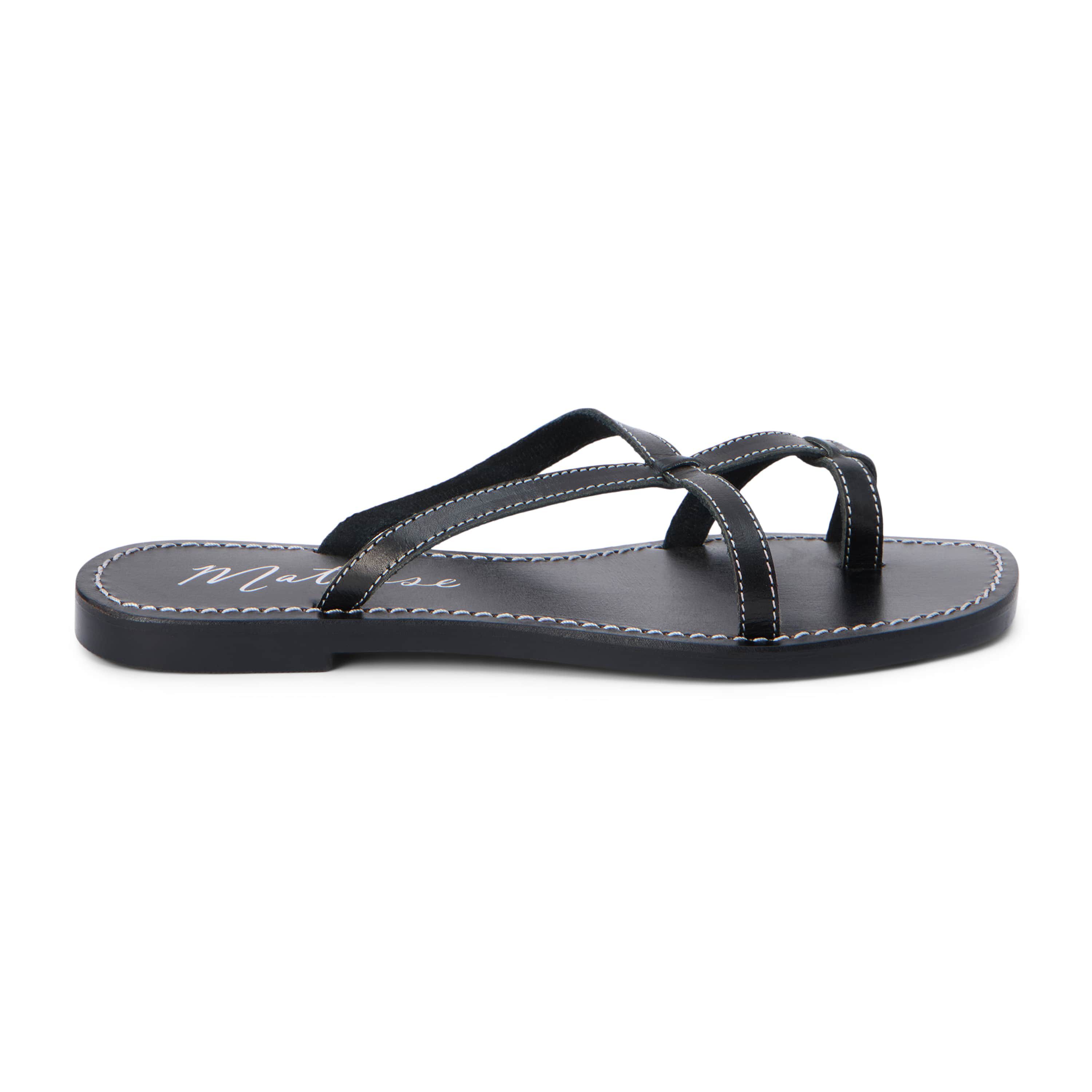 Flat sandal with criss-cross straps and toe thong.