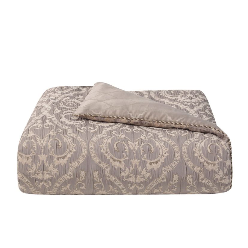 The rich Waterford Fine Linens Hazeldene bedding set is a beautiful allover taupe design. The woven jacquard comforter has a pucker construction creating exquisite dimension. Coordinating pillow shams add shine and are finished with an elegant accent and corded trim.   Included in the set is a ruffled taupe bedskirt and textured euro shams with a ruched border and fringe accent reversing to an hourglass design.  Queen dimensions: Comforter 92" x 96", Std Sham 20" x 26",  European Sham 26" x 26" Bed Skirt 60" x 80" with 16" drop, King dimensions: Comforter 110" x 96", King Shams 20" x 36", European shams 26" x 26" and Bed Skirt 72" x 84" with 16" drop.  Dry Clean Only.