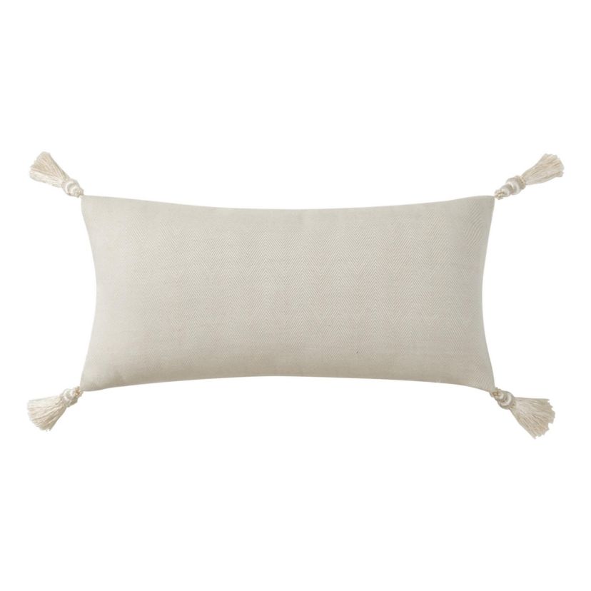 The ivory Arderra 11" x 22" exquisite decorative pillow features an embroidered leaf design. The pillow reverses to a herringbone pattern and is finished with four corner tassels.